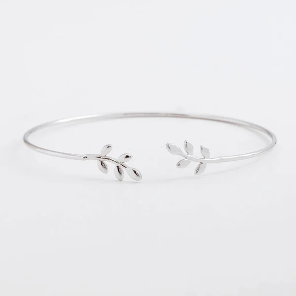 Luxurious slim beautiful silver bracelet with leaves on a gray background — Stock Photo, Image