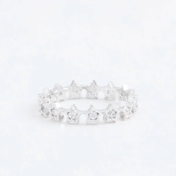 Lujosas estrellas de anillo de joyería de plata con cristales transparentes, gotas de diamantes de imitación, sobre un fondo gris — Foto de Stock