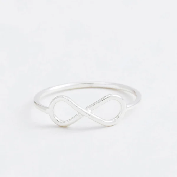 Luxury silver jewelry ring infinity with a grey background — Stock Photo, Image