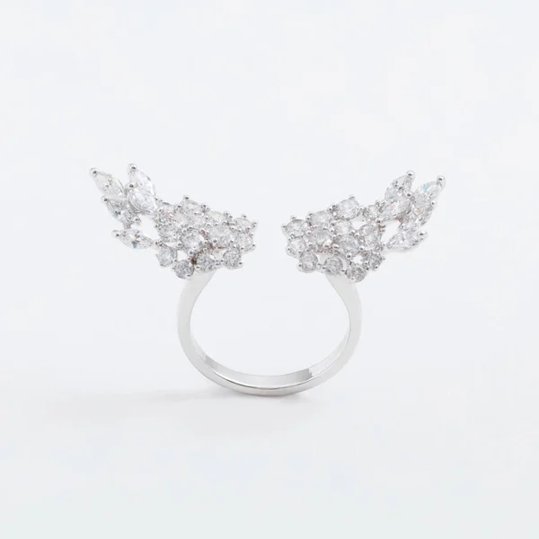 Luxurious silver jewelry ring with wings of crystals with a gray background — Stock Photo, Image