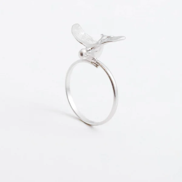 Luxueuse bague bijoux en argent avec un oiseau sur fond gris — Photo