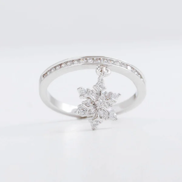 Luxuriöse schöne Silberschmuckring mit Kristallen und Strass, mit einer dekorativen Schneeflocke auf grauem Hintergrund — Stockfoto