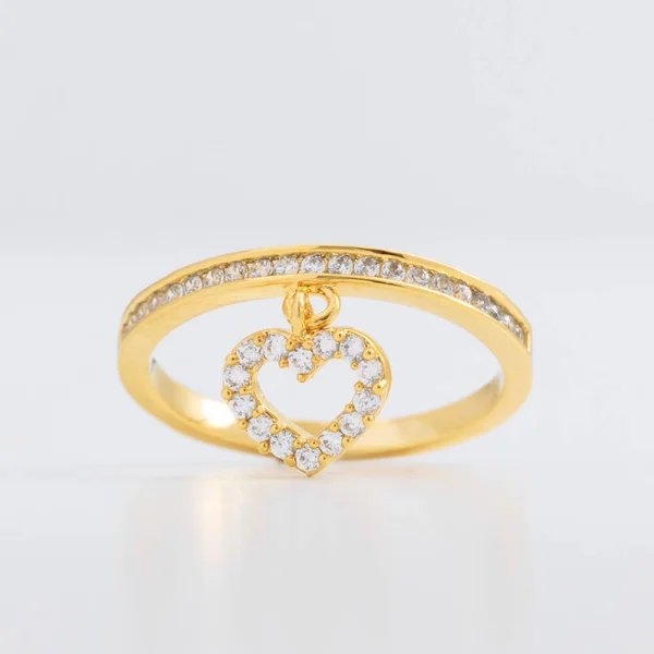 Luxueuse bague bijoux en or avec cristaux et strass, avec un cœur décoratif sur fond gris — Photo