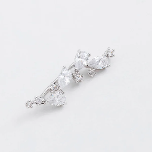 Lyxiga vackra ljus glänsande silver Cufförhänge, med kristaller, droppar på en grå bakgrund — Stockfoto