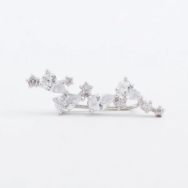 Luxus schöne leicht glänzende silberne Manschettenohrring, mit Kristallen, Tropfen auf einem grauen Hintergrund — Stockfoto