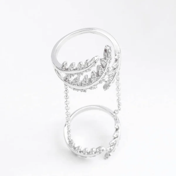 Luksusowy, piękny jasny srebrny podwójnym pierścieniem z łańcuchów i kryształy liści na szarym tle — Zdjęcie stockowe