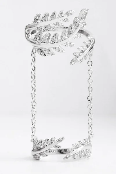 Luxus schöne hellsilberne Doppelring mit Ketten und Kristallen Blätter auf einem grauen Hintergrund — Stockfoto