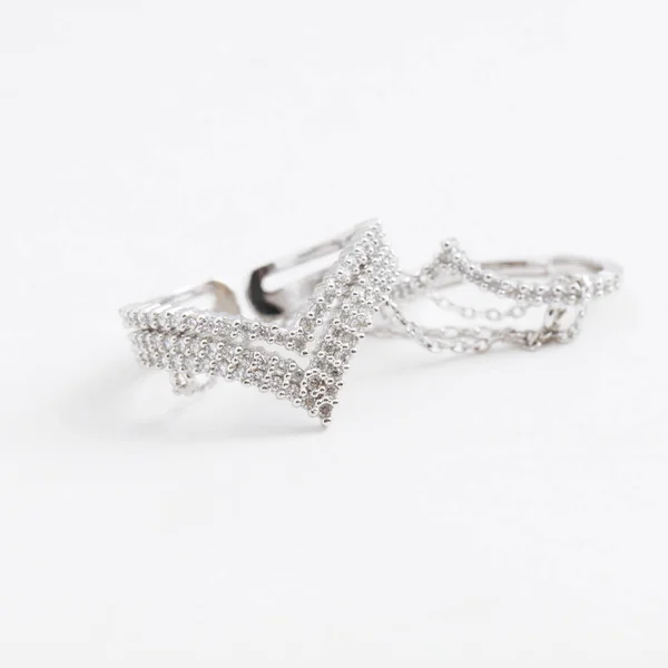 Luksusowy piękny srebrny pierścień podwójne z łańcuchów i kryształy na szarym tle — Zdjęcie stockowe