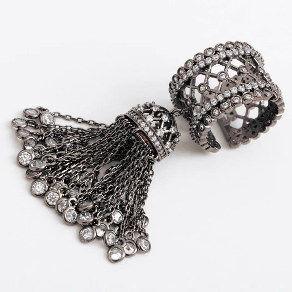 Piękne luksusowe ciemny srebrny pierścień z łańcuchów i kryształy na szarym tle — Zdjęcie stockowe