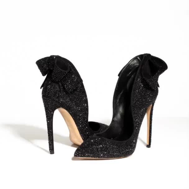 Черные роскошные женские туфли на высоких каблуках двигаются на белом фоне — стоковое видео