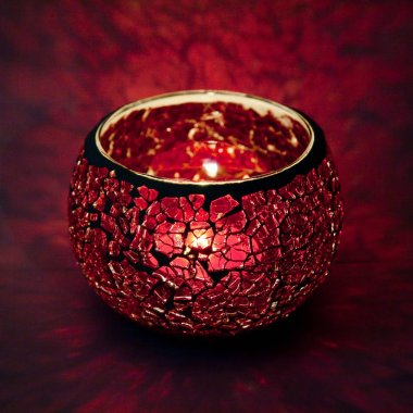 Pembe cam içinde parlayan bir mum ışık ışınları ile bir güzel şamdan top