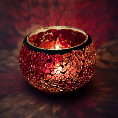 Kırmızı ve pembe cam içinde parlayan bir mum ışık ışınları ile bir güzel şamdan top