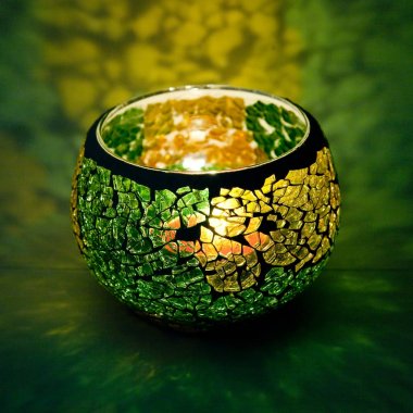 Sarı ve yeşil cam içinde parlayan bir mum ışık ışınları ile bir güzel şamdan top