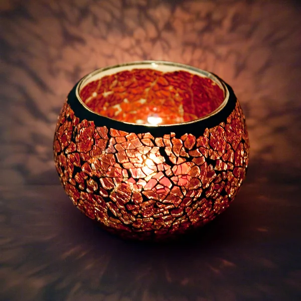 Çok renkli cam içinde parlayan bir mum ışık ışınları ile bir güzel şamdan top