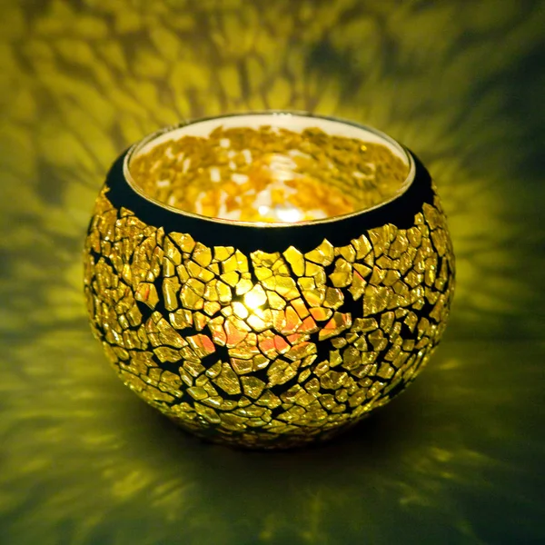 Sarı cam içinde parlayan bir mum ışık ışınları ile bir güzel şamdan top