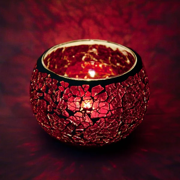 Pembe cam içinde parlayan bir mum ışık ışınları ile bir güzel şamdan top