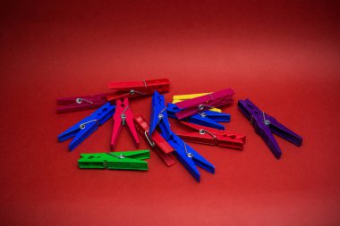 Kırmızı arkaplana saçılmış mandallar