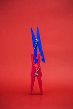 İki elbise askısı, kırmızı bir arka plan.