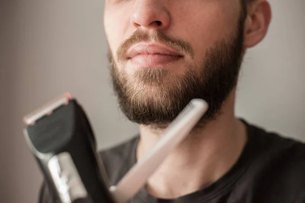 Homem Rapa Sua Barba Com Uma Navalha Elétrica — Fotografia de Stock