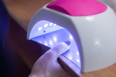 Çivileri ultraviyole ve teknik ile kurutmak için manikür cihazı.