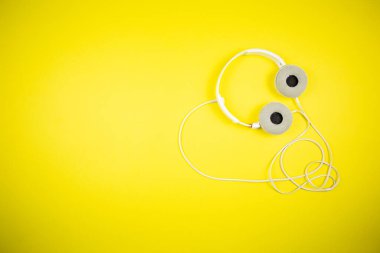 Sarı arka planda 3.5 mm 'lik kabloyla beyaz kulaklıklar.