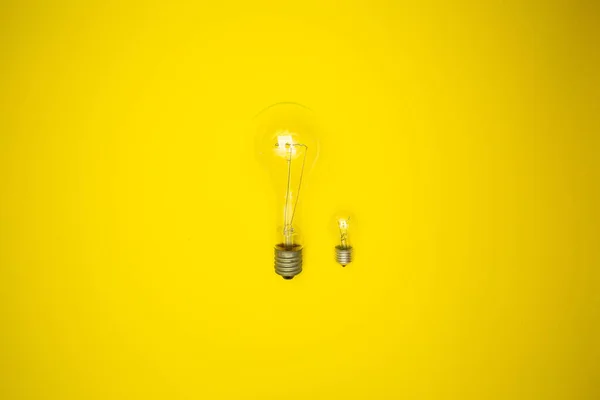 Two Bulbs Large Small Yellow Background — Stock Photo, Image