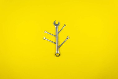 Sarı arka planda farklı boyutlarda anahtarlar.