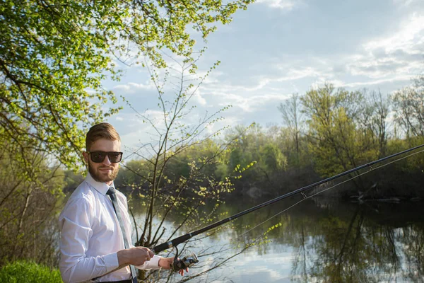 一个穿着西装 白衬衫和领带的男人在钓鱼 — 图库照片