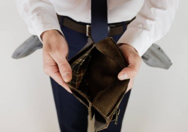 Takım elbiseli bir adam elinde parasız boş bir cüzdan tutuyor. Finansal kriz. İflas, iş dünyasında. İşveren hayal kırıklığına uğradı..