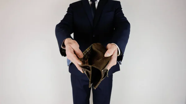 スーツを着た男がお金のない財布を手に持っている 金融危機 事業の破産 雇用主は失望している — ストック写真