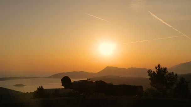 Un jeune homme s'entraîne au coucher du soleil — Video