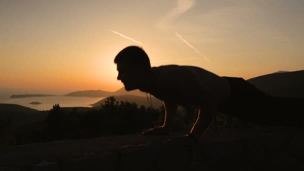 Junger Mann trainiert bei Sonnenuntergang — Stockvideo