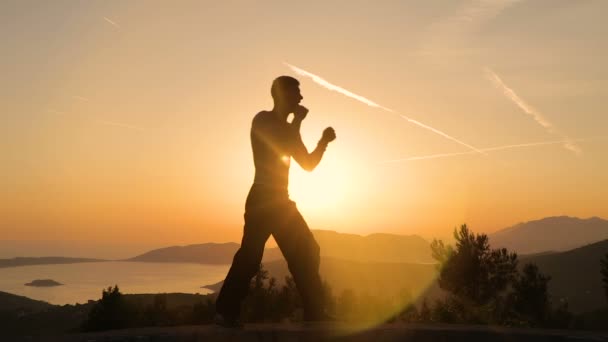 Hombre joven entrenando al atardecer — Vídeo de stock