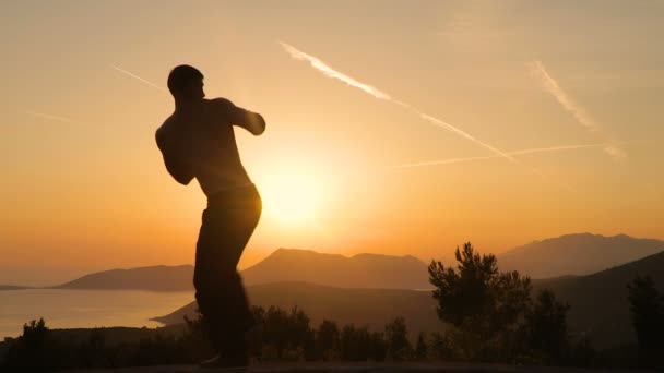 Hombre joven entrenando al atardecer — Vídeos de Stock