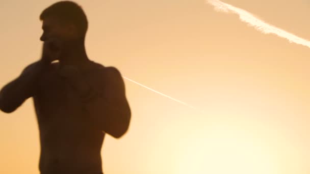 Hombre joven entrenando al atardecer — Vídeos de Stock