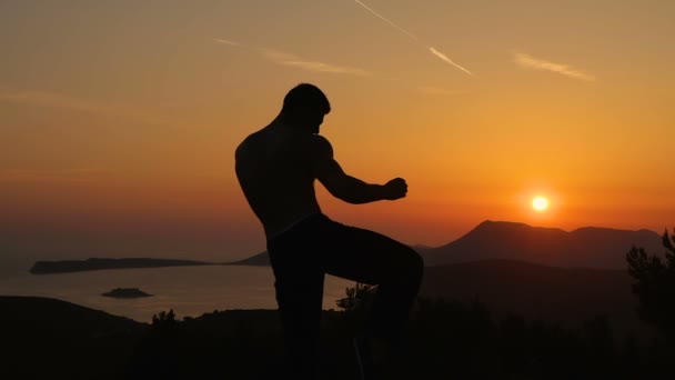 Un jeune homme s'entraîne au coucher du soleil — Video