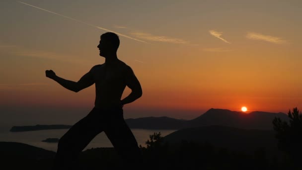 Hombre joven entrenando al atardecer — Vídeos de Stock