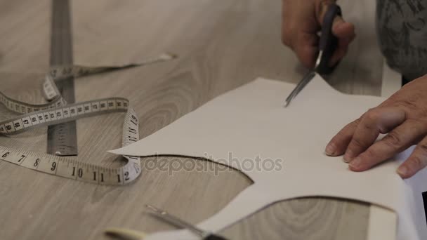 Designer cuts a template for the dress of white leather. tracking shot. in slow motion — Stock Video