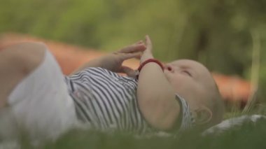 Küçük bir çocuk üzerinde çim sırıtıyor yatıyor ve yakın çekim çalış