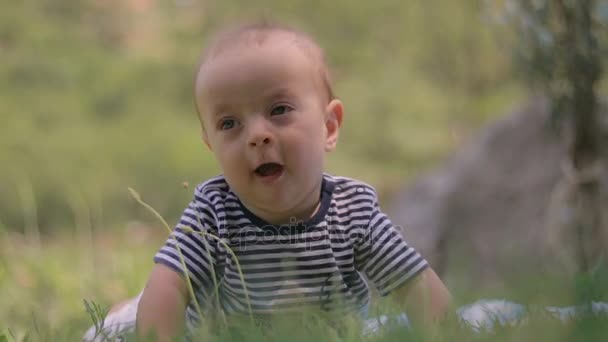 Un bambino piccolo giace sull'erba piange primo piano — Video Stock