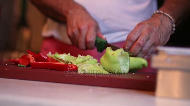 Oogpunt van man hakken van tomaat en paprika salade — Stockvideo