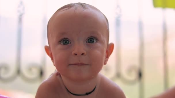 Baby-boy baadt glimlachend na zwembad — Stockvideo