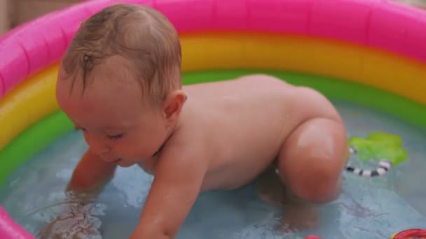 Baby-boy baadt in een pool — Stockvideo