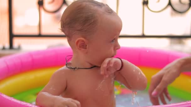 男の子の赤ちゃんが降り注ぐプール — ストック動画