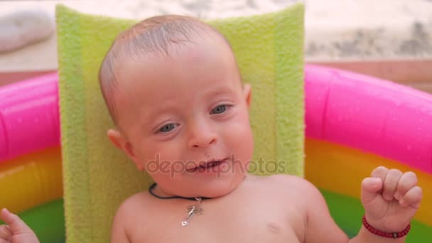 Baby-boy baadt in een pool — Stockvideo