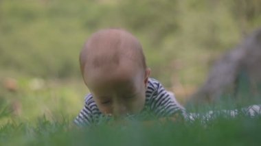 Küçük bir çocuk çim cry yakın çekim üzerinde yatıyor