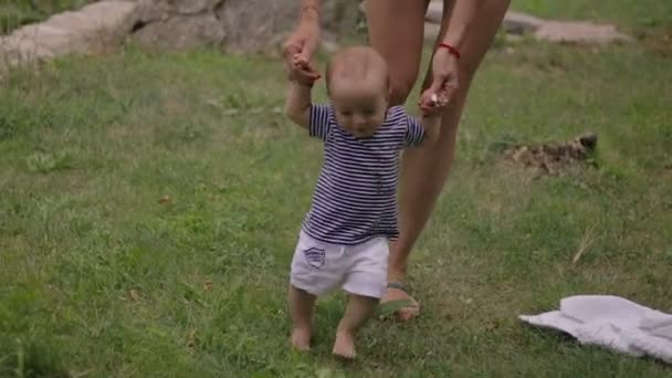Bebé primeros pasos en la hierba — Vídeo de stock