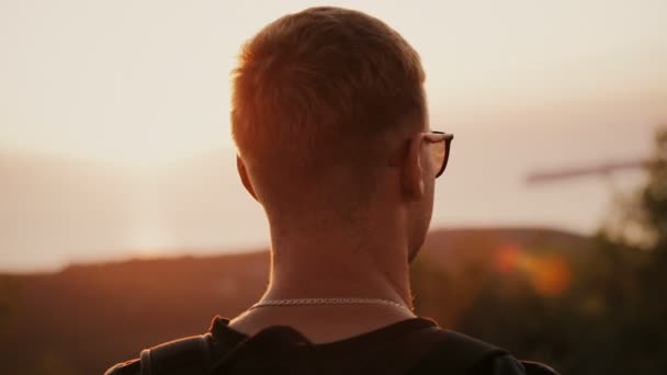 Hombre mirando la vista de las montañas bajo el atardecer — Vídeo de stock