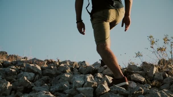 Een man met een grote rugzak is het beklimmen van een berg. Jonge man beoefenen van gezonde actieve levensstijl. — Stockvideo