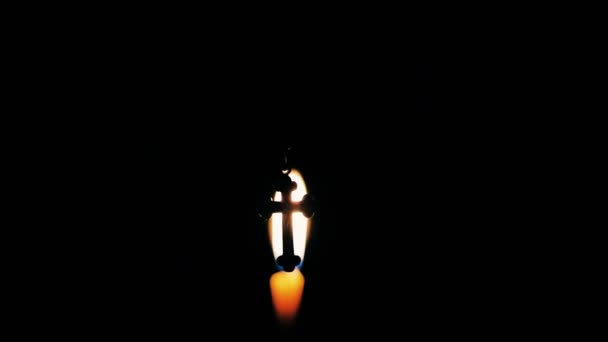Σταυρός σε φόντο ένα αναμμένο κερί στην εκκλησία — Αρχείο Βίντεο